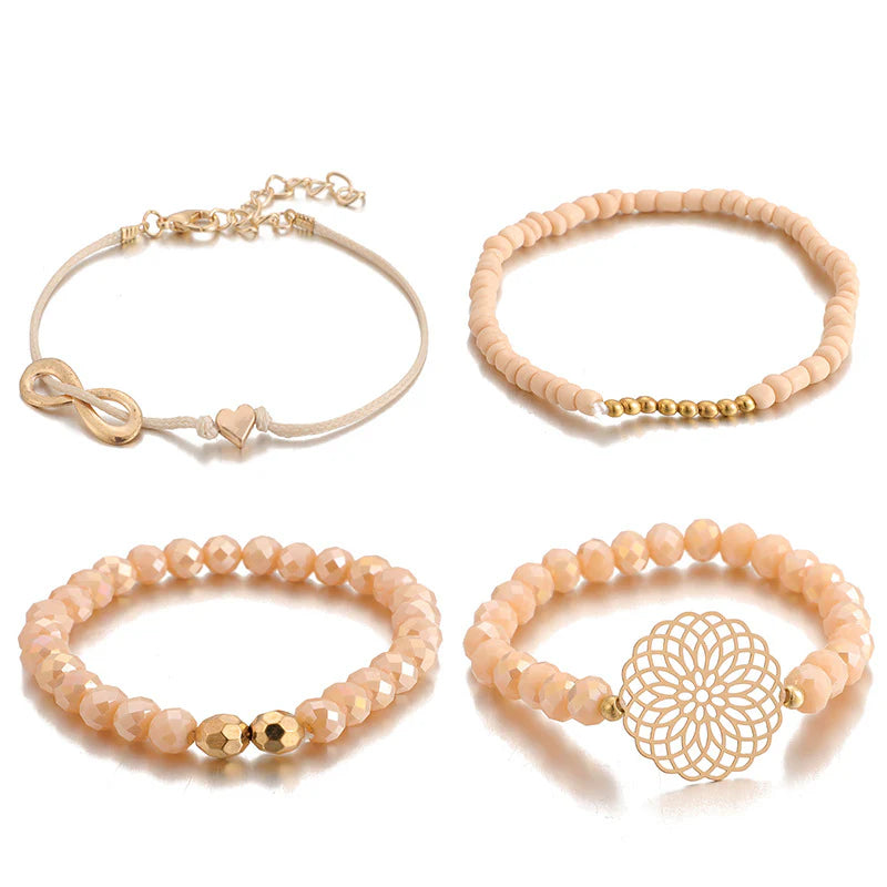 Layered bracelet set featuring four coordinated bracelets with pink geometric accents and gold details.
