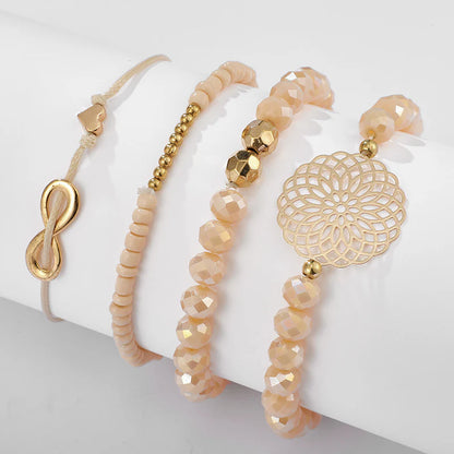 Layered bracelet set featuring three pieces with gold and pink geometric accents for a trendy layered look.