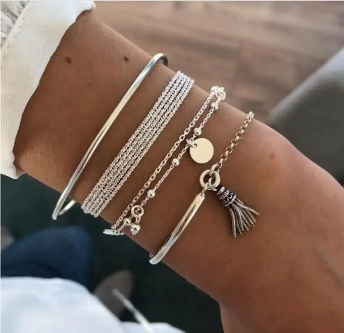 Layered bracelet set featuring silver-tone tassel accents and coordinating designs for a stylish look.