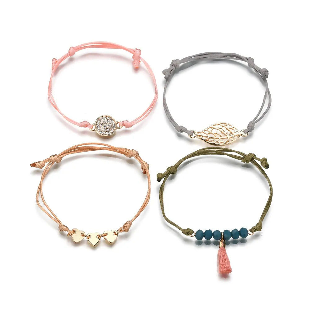 Layered bracelet set featuring four bohemian cord bracelets in pink, gray, orange, and green for a chic layered look.