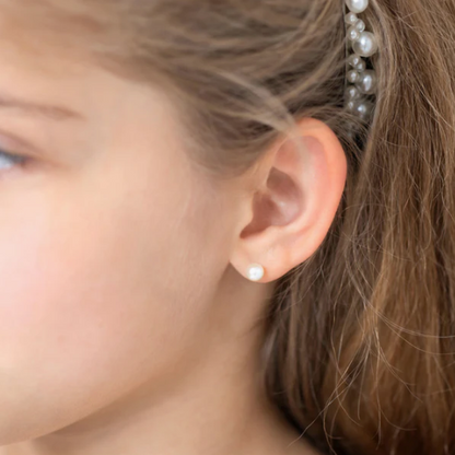 Close-up of girl wearing pearl earrings, showcasing 14k yellow gold freshwater cultured pearl screw backs.