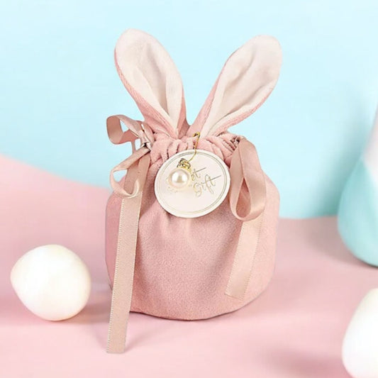 A pink velveteen gift bag with rabbit ears and a bow, designed for holding jewellery or other gifts.