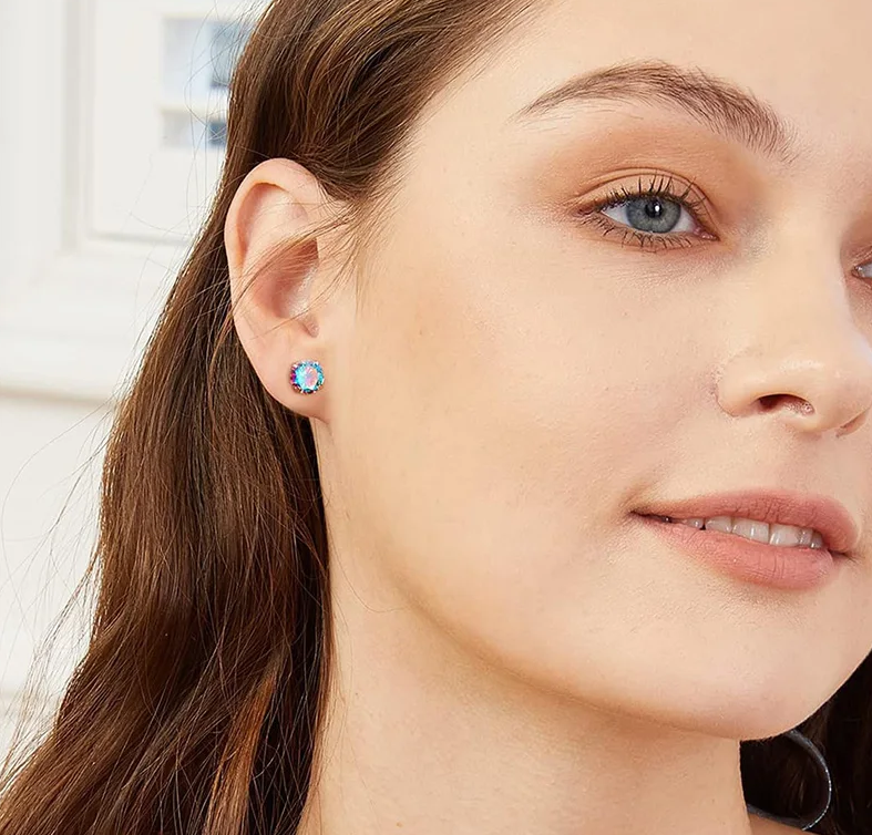 Rainbow CZ stud earrings worn by a model, showcasing dazzling aurora borealis cubic zirconia and surgical steel design.