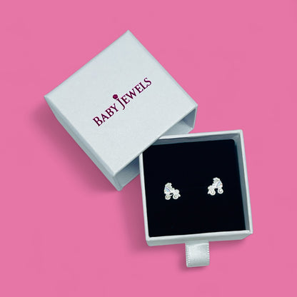 Silver rollerblade earrings in a 'Baby Jewels' box on a pink background