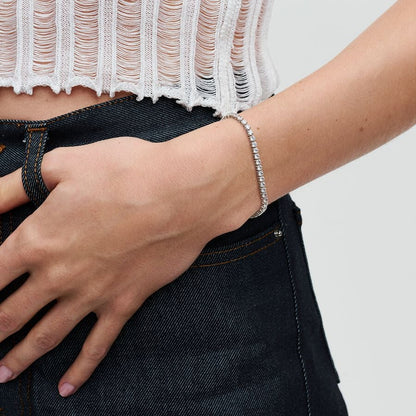 close up of a teenage girls arm wearing a clear cubic zirconia tennis bracelet on her wrist