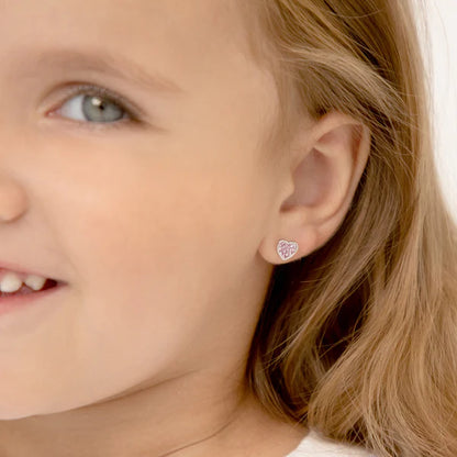 Close-up of a child wearing a heart-shaped earring.