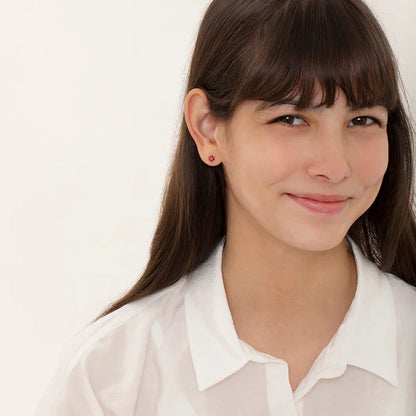 Girl smiling while wearing sterling silver birthstone stud earrings with screw backs.
