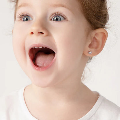 Girl wearing sterling silver flower stud earrings with safety screw backs