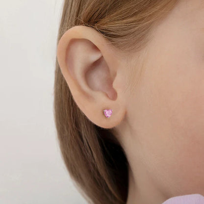 Child model wearing pink heart earrings - side view showing safety screw back design