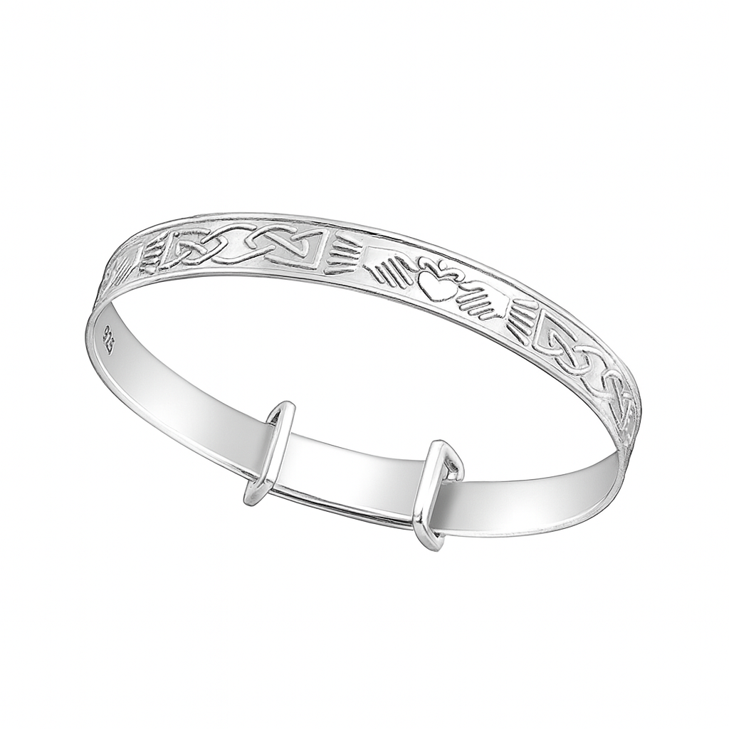Sterling silver expandable baby bangle engraved with Celtic knot and Claddagh heart, hands, and crown motifs, shown on a plain white background.