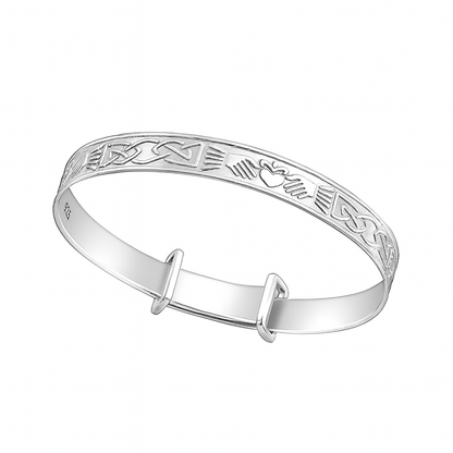 Sterling silver expandable baby bangle engraved with Celtic knot and Claddagh heart, hands, and crown motifs, shown on a plain white background.