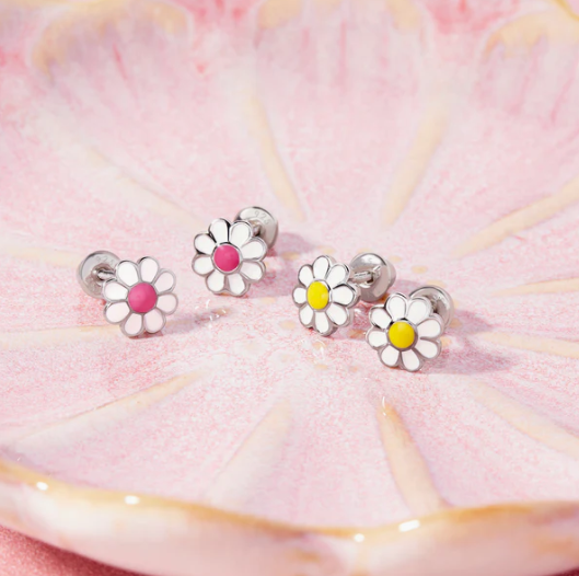 Set of four daisy-shaped earrings with colored centers on a pink and yellow background