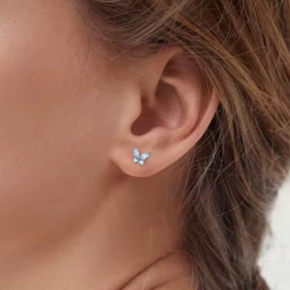 Children's earrings featuring sparkling pink CZ crystal butterfly studs on a child's ear.