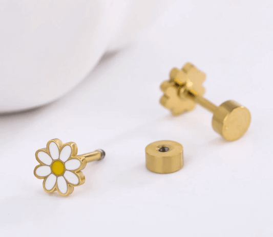 Three components of a gold‑plated barbell earring arranged on a white surface: a daisy‑shaped stud with white enamel petals and a yellow centre, a loose cylindrical screw‑on backing showing its threaded hole, and a matching stud with its flower‑shaped backing attached.