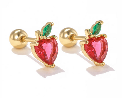 A pair of children's earrings featuring a reversible design with one side being a red strawberry shape and the other side a gold ball stud, set against a white background.