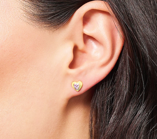 Pink CZ heart earrings in gold on child's ear – hypoallergenic jewellery