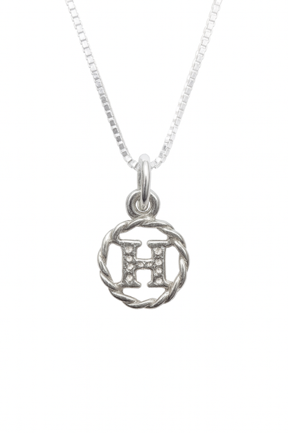 Silver necklace with a circular pendant featuring the letter 'H' on a white background