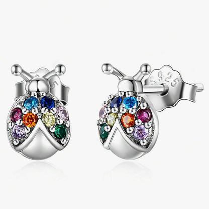 Pair of sterling silver ladybug stud earrings adorned with multi-coloured gemstones, displayed on a white background
