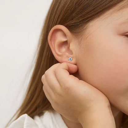 Multicolour CZ Flower Earrings on a young girl's ear, showcasing a delicate and charming design.