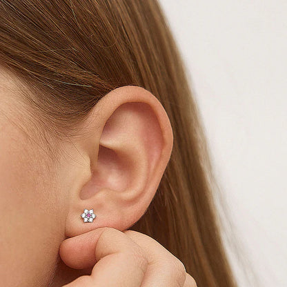 Close-up of a child's ear wearing Multicolour CZ Flower Earrings in sterling silver.