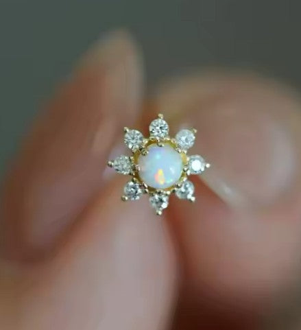 a close up image of an opal and clear cz flower shaped stud earring