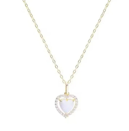 a yellow gold necklace with a white opal heart pendant surrounded by a halo of clear cubic zirconia