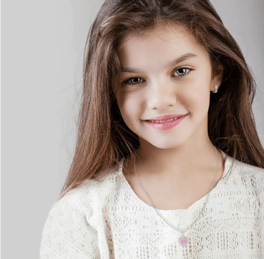 Model wearing sterling silver pink heart necklace and mini huggie hoop earrings
