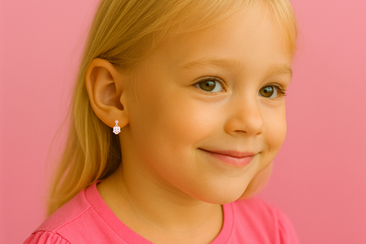 Young girl with blonde hair and pink shirt against a pink background with little pink cubic zirconia studs featuring pink enamel owl charms
