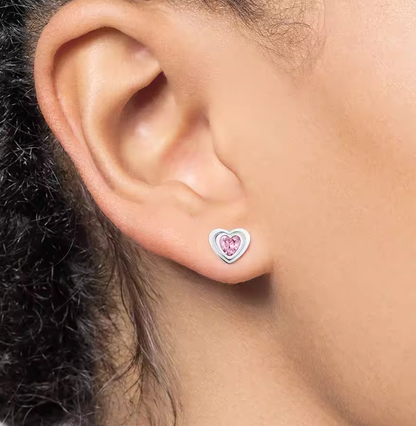 Child wearing pink heart CZ stud earrings – girls sterling silver studs
