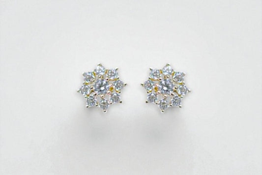 Pair of silver flower-shaped earrings on a light gray background