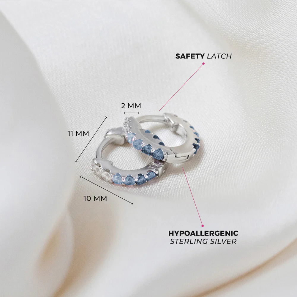Children's earrings in sterling silver with paved blue CZ, featuring a safety latch and hypoallergenic design.