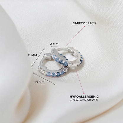 Children's earrings in sterling silver with paved blue CZ, featuring a safety latch and hypoallergenic design.