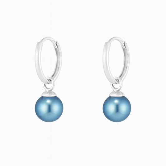 Pair of silver earrings with blue pearl drops on a white background