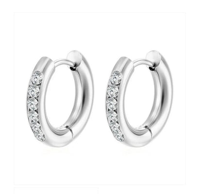 A pair of silver-coloured hypoallergenic steel huggie hoop earrings with clear cubic zirconia accents.