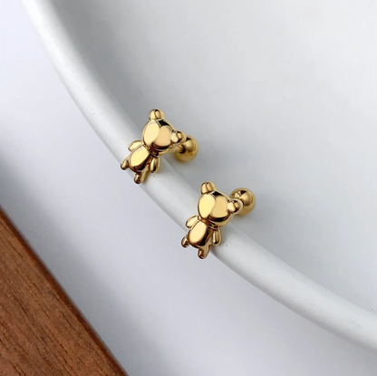 Gold teddy bear-shaped earrings on a white background.