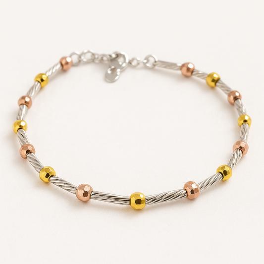 Children’s tri-colour beaded bracelet with alternating twisted silver rods and polished gold and rose-gold beads, arranged in a circle on a soft, nearly white background.