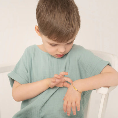 Child admiring the Figaro Bracelet - 14k Yellow Gold Classic Chain on wrist, showcasing elegance and quality.