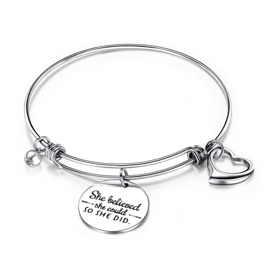 Charm bangle featuring an open heart charm and engraved encouragement disc, made of hypoallergenic surgical steel.