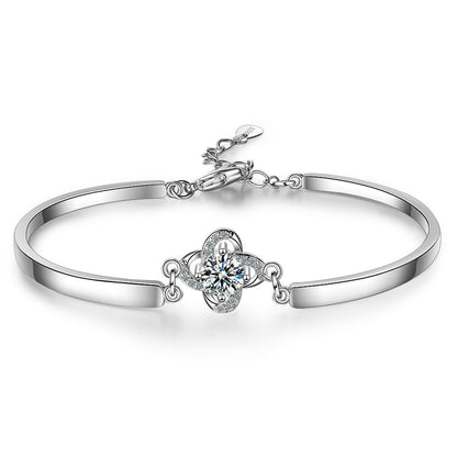 A sterling silver bangle bracelet with a central cubic zirconia flower and additional extension links.