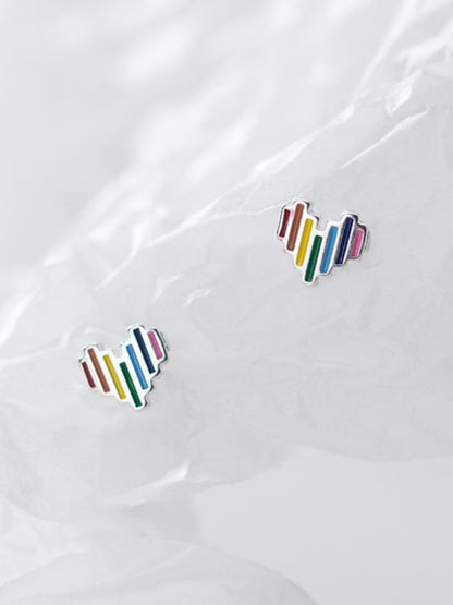 Pair of sterling silver heart studs with multi-coloured vertical stripes, artfully arranged on crumpled white tissue paper