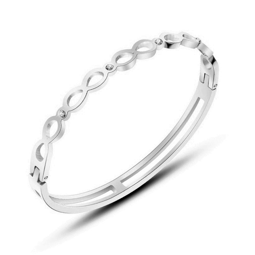 Surgical steel bangle featuring clear cubic zirconia and elegant opening design, perfect for sensitive skin.