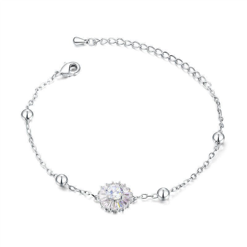 Delicate titanium steel bracelet with cubic zirconia flower centerpiece and polished steel balls.