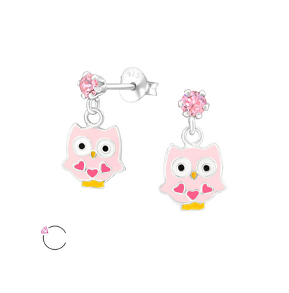 A pair of sterling silver dangly owl earrings with pink details and a small crystal at the top.