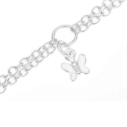 Close up of a butterfly charm on a silver children's double chain charm bracelet on a white background