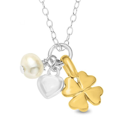 Close up of a sterling silver cluster necklace with a gold over silver lucky clover, a pearl, and a silver puffy heart, designed for children.